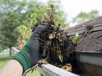 Debris being removed from a blocked gutter